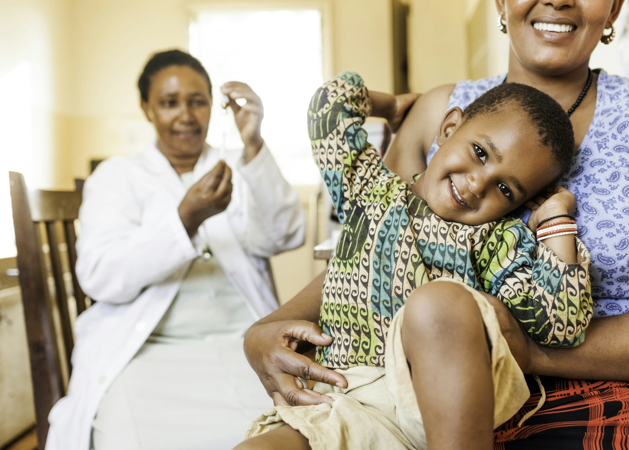Medicine being distributed to smiling child and mother